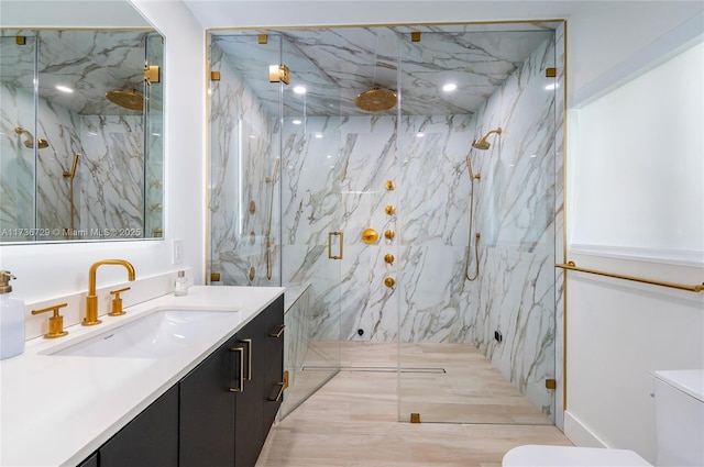 bathroom with walk in shower, vanity, and toilet