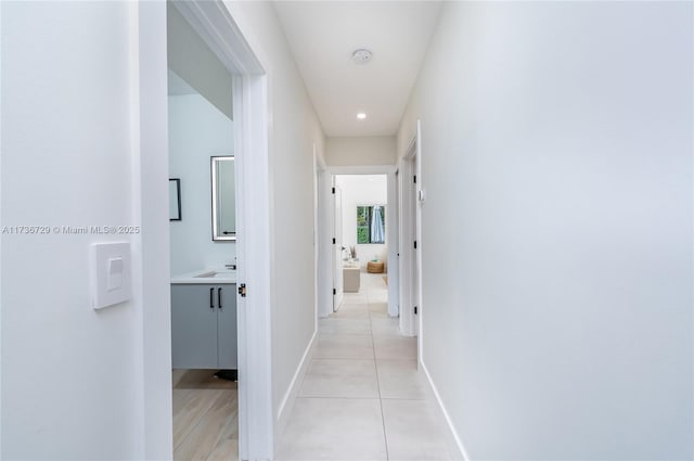 hallway with sink and light tile patterned floors