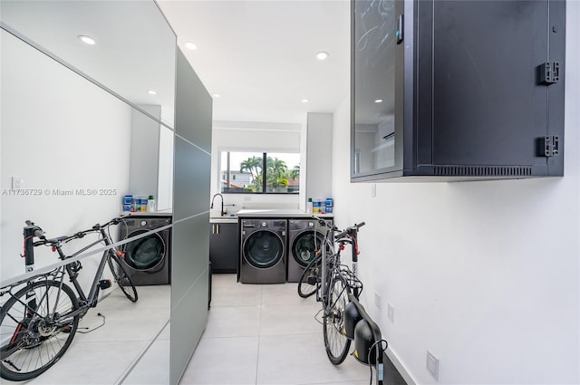 washroom with cabinets, sink, washer and dryer, and light tile patterned flooring