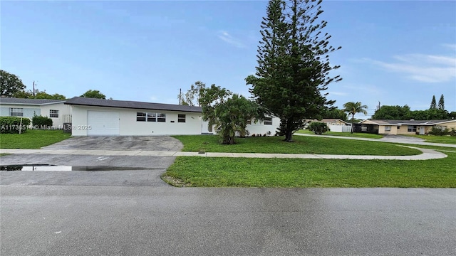 single story home with a garage and a front lawn