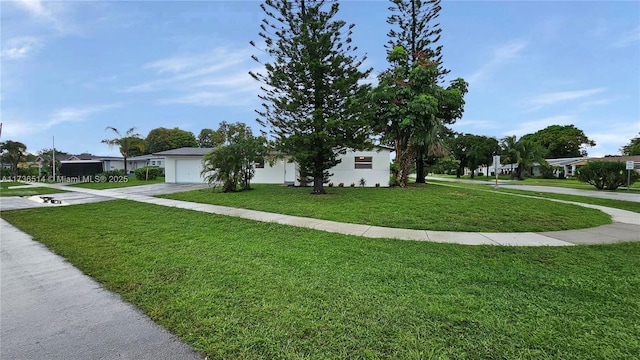 view of front of house featuring a garage and a front lawn