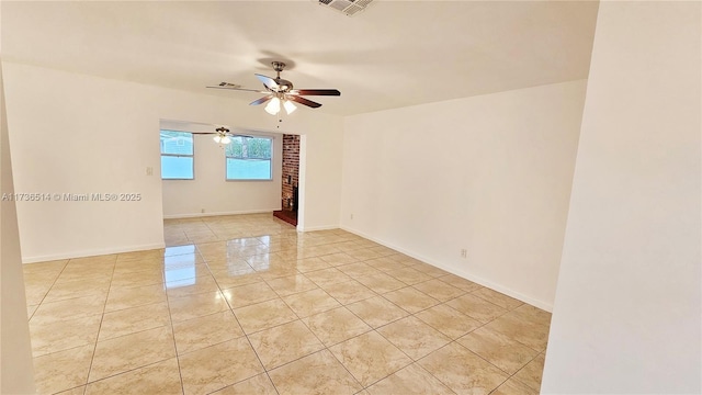 tiled empty room featuring ceiling fan