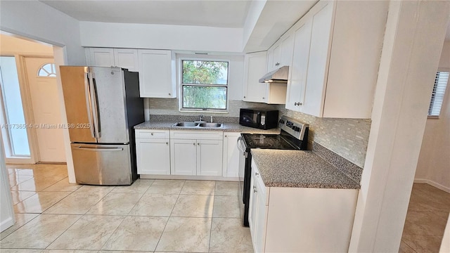 kitchen with light tile patterned flooring, appliances with stainless steel finishes, sink, white cabinets, and decorative backsplash