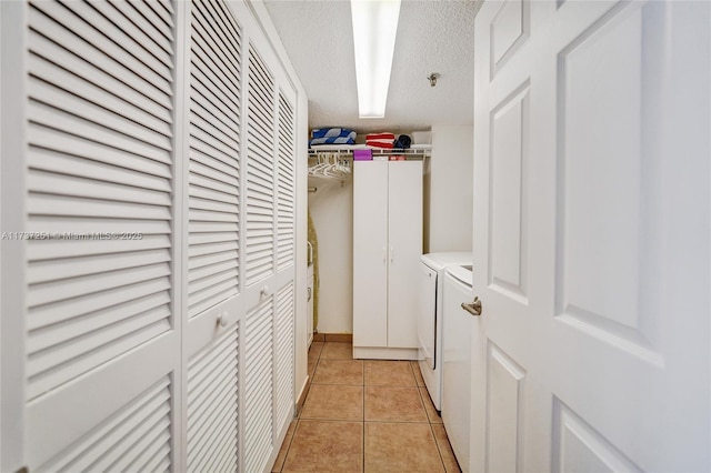 laundry room featuring light tile patterned flooring, washer and dryer, and a textured ceiling