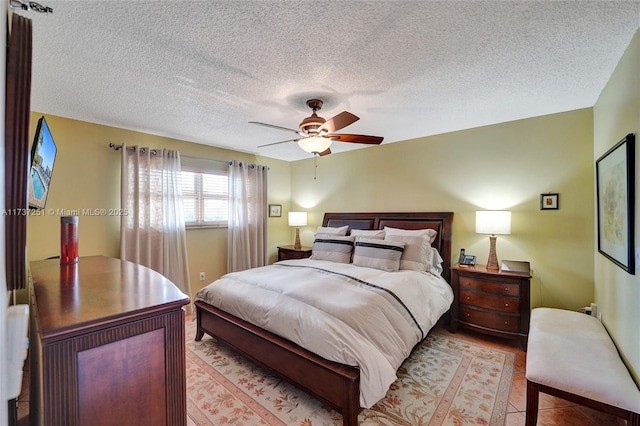 tiled bedroom with a textured ceiling and ceiling fan