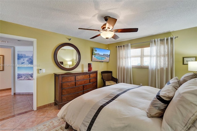 tiled bedroom featuring ceiling fan and a textured ceiling