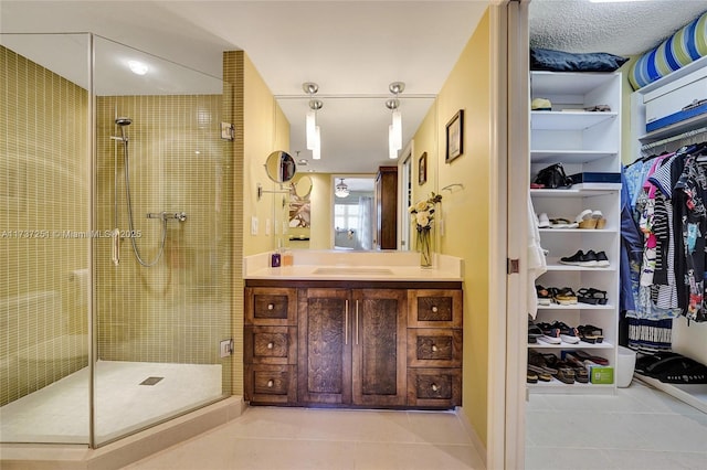 bathroom with tile patterned floors, a shower with door, and vanity