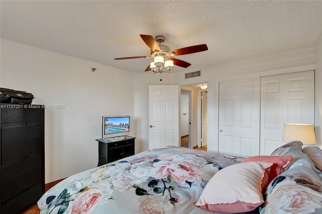 bedroom with ceiling fan, a textured ceiling, and a closet