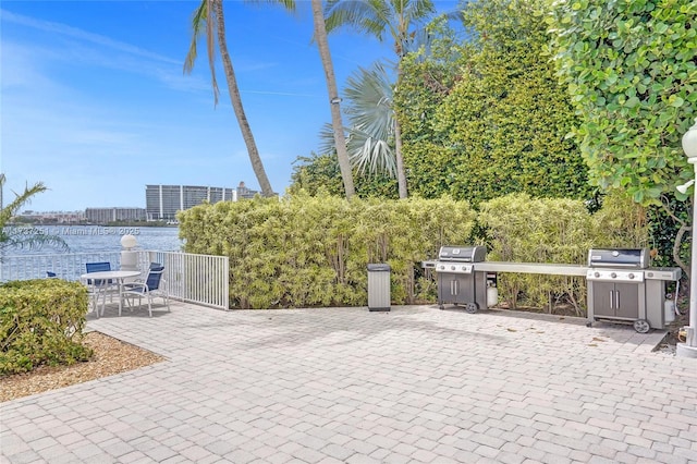 view of patio with a water view and grilling area