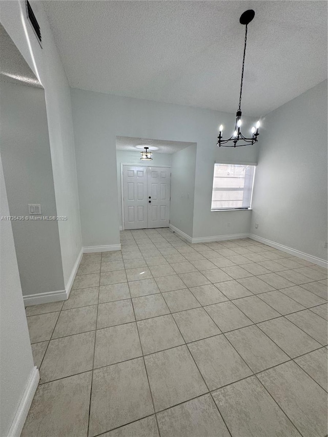 interior space featuring a chandelier, a textured ceiling, and light tile patterned flooring