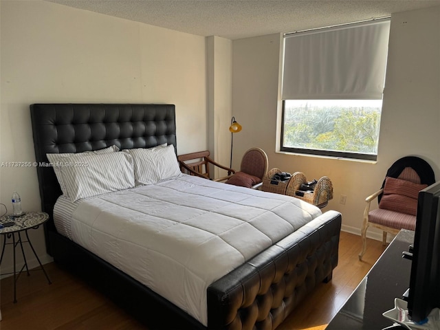 bedroom featuring hardwood / wood-style flooring and a textured ceiling