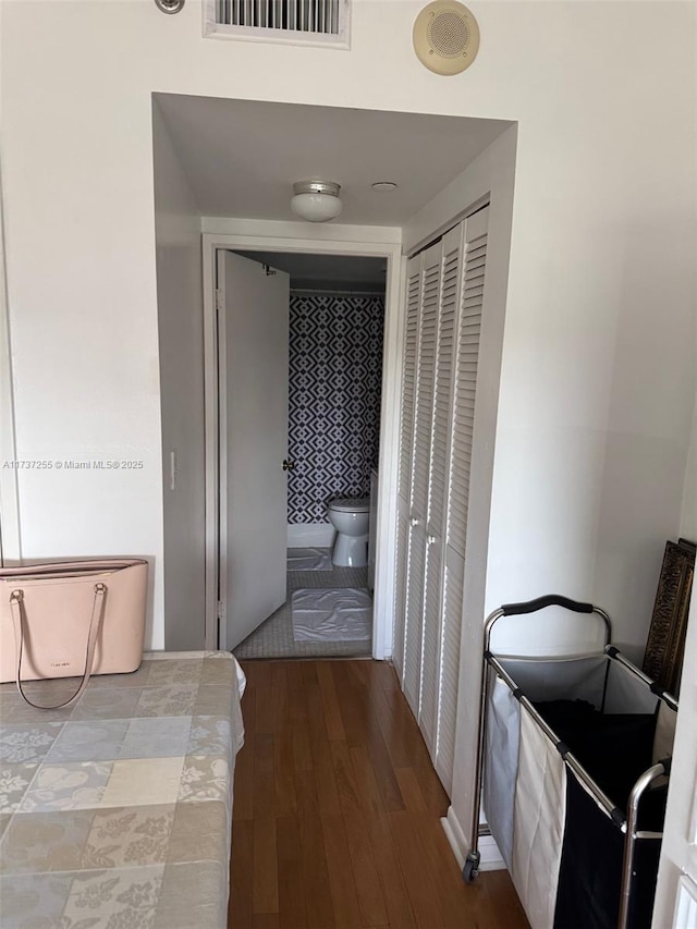 bedroom with hardwood / wood-style floors, a closet, and ensuite bathroom