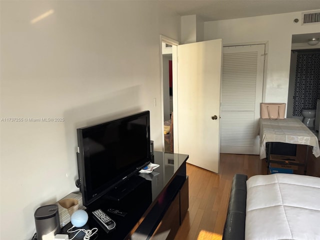 bedroom with light hardwood / wood-style floors and a closet