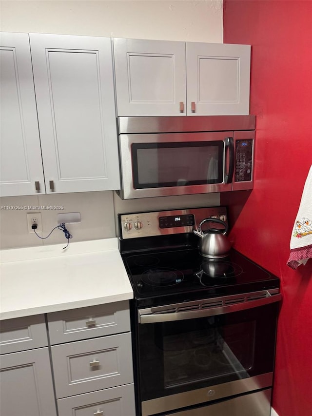 kitchen featuring white cabinetry and appliances with stainless steel finishes