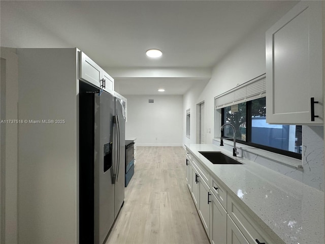 860 NW 171st St, Miami Gardens, FL 33169 - kitchen featuring white cabinetry, sink, light stone counters, stainless steel fridge with ice dispenser, and light hardwood / wood-style flooring