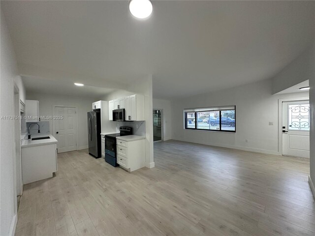 860 NW 171st St, Miami Gardens, FL 33169 - kitchen with appliances with stainless steel finishes, sink, white cabinets, and light hardwood / wood-style floors
