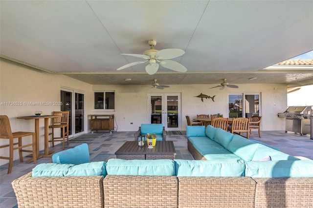 view of patio / terrace featuring area for grilling, an outdoor hangout area, ceiling fan, and french doors