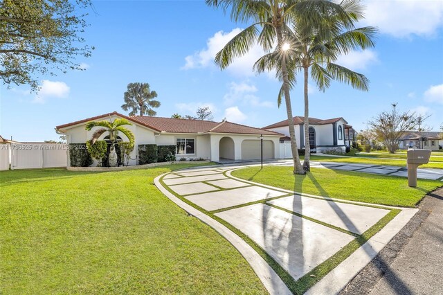 mediterranean / spanish-style house featuring a garage and a front lawn