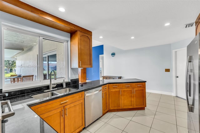 kitchen featuring sink, light tile patterned floors, kitchen peninsula, and appliances with stainless steel finishes