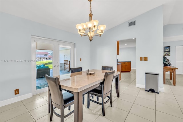 dining room featuring lofted ceiling, light tile patterned floors, a notable chandelier, and french doors