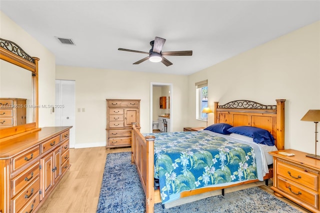 bedroom with ensuite bath, light hardwood / wood-style flooring, and ceiling fan