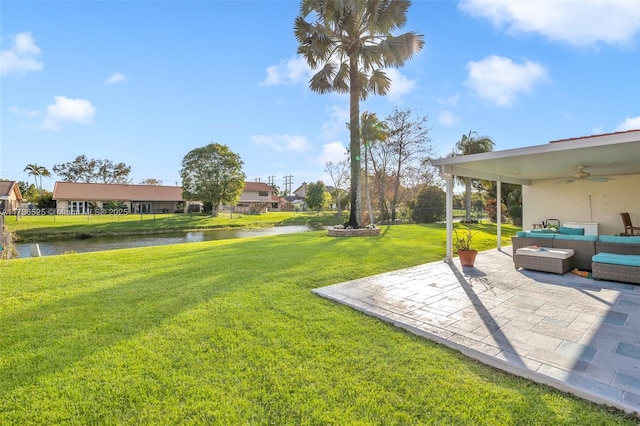 view of yard with a water view, an outdoor hangout area, ceiling fan, and a patio area