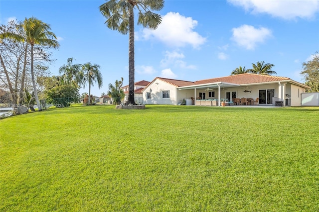 rear view of house with a yard and ceiling fan