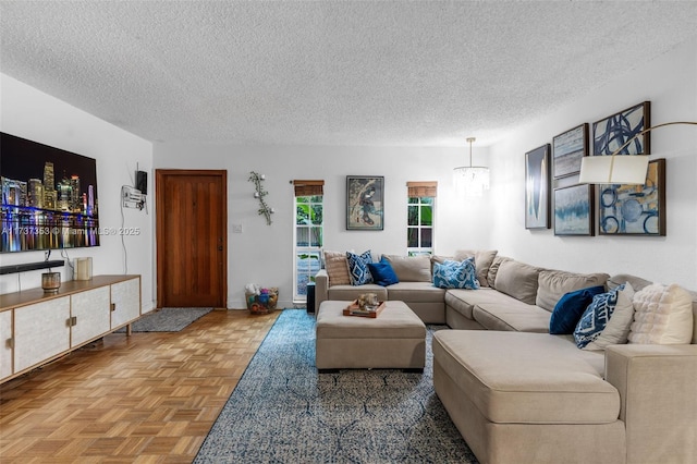 living room with an inviting chandelier, a textured ceiling, and light parquet flooring