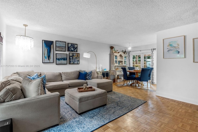 living room featuring an inviting chandelier, parquet flooring, and a textured ceiling