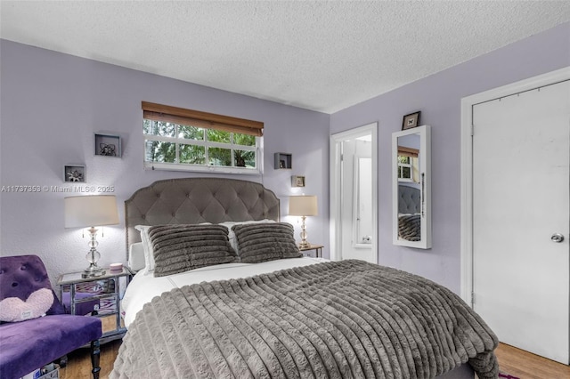 bedroom with wood-type flooring and a textured ceiling