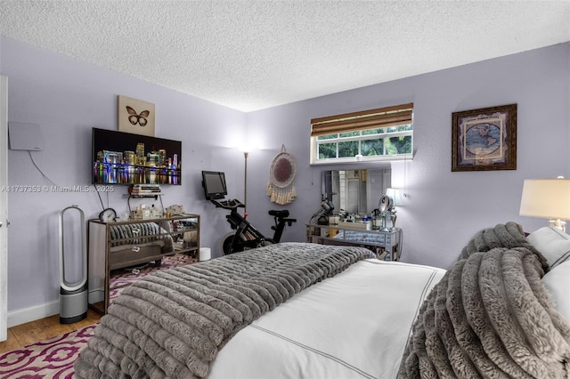 bedroom featuring hardwood / wood-style floors and a textured ceiling