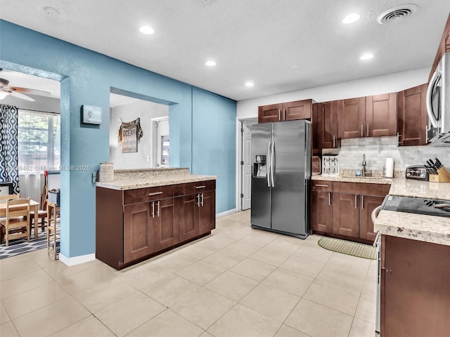 kitchen featuring appliances with stainless steel finishes, tasteful backsplash, sink, light tile patterned floors, and ceiling fan