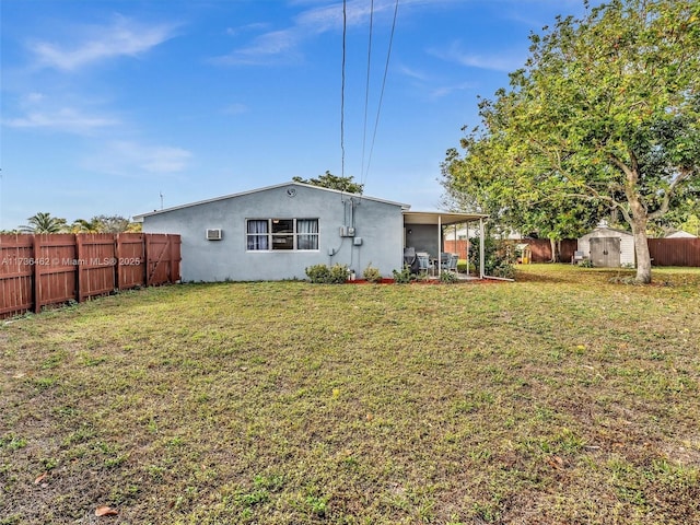 back of property featuring a storage shed, a yard, and a wall mounted AC