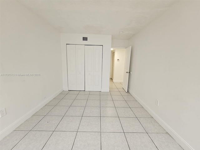 unfurnished bedroom with a closet and light tile patterned flooring