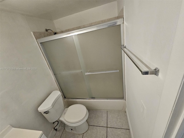 bathroom featuring bath / shower combo with glass door, tile patterned floors, and toilet