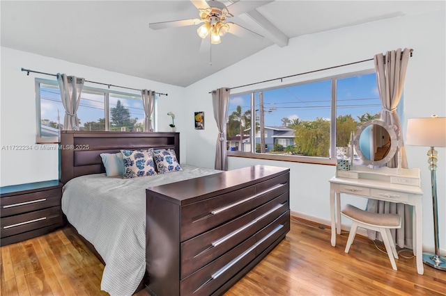 bedroom featuring multiple windows, vaulted ceiling with beams, and light hardwood / wood-style floors