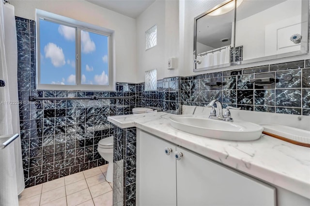bathroom with tile walls, vanity, tile patterned flooring, and toilet