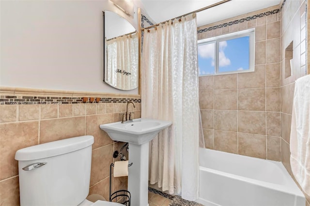 bathroom featuring tile patterned floors, toilet, shower / tub combo, and tile walls