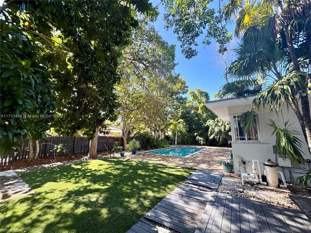 view of swimming pool with a wooden deck and a lawn