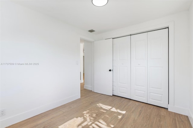 unfurnished bedroom with light hardwood / wood-style floors and a closet