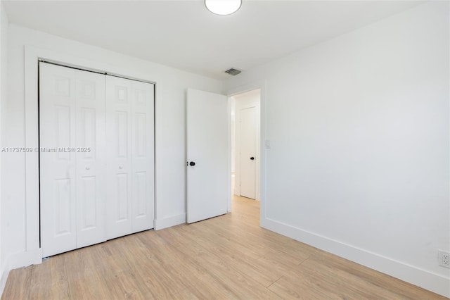 unfurnished bedroom with light hardwood / wood-style floors and a closet