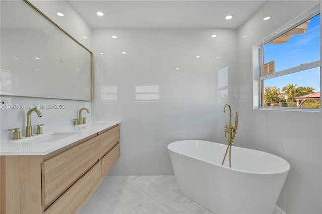 bathroom with a tub to relax in, vanity, and tile walls