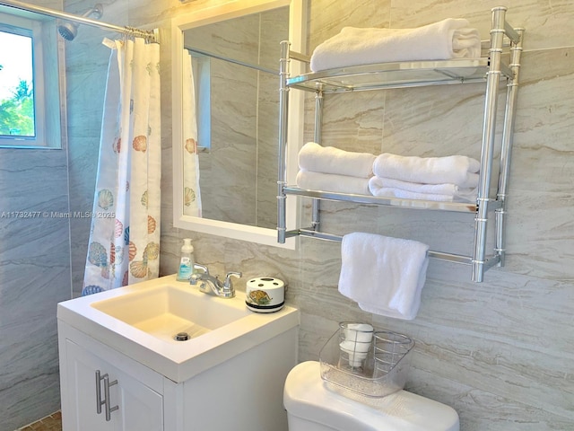 bathroom featuring a shower with curtain, vanity, tile walls, and toilet