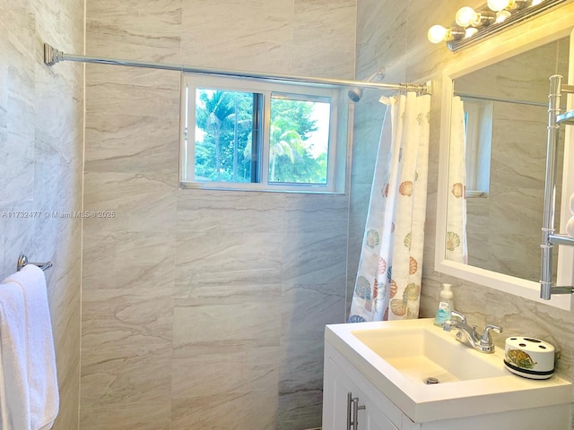 bathroom featuring vanity, tasteful backsplash, tile walls, and walk in shower