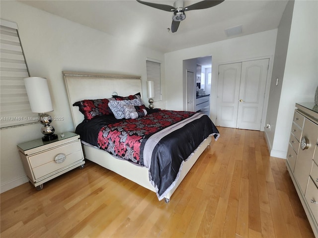 bedroom featuring a ceiling fan, connected bathroom, light wood-style flooring, and baseboards