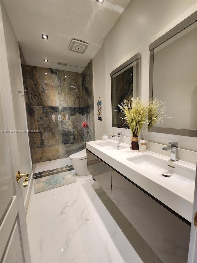 full bathroom with marble finish floor, a sink, a tile shower, and toilet