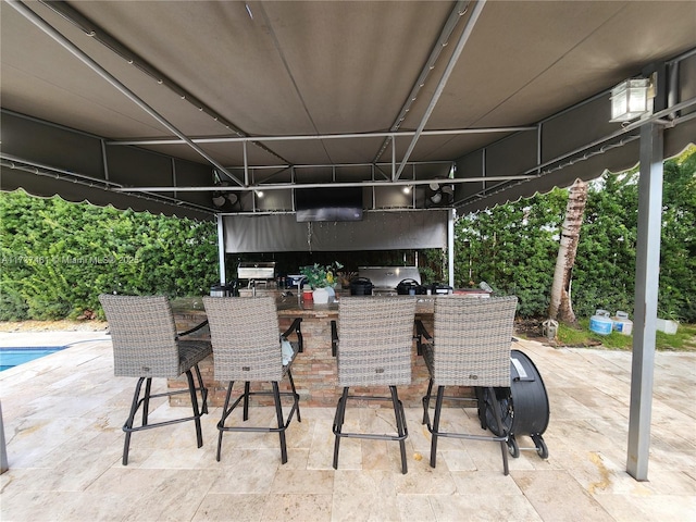 view of patio / terrace with outdoor dry bar, an outdoor kitchen, and a grill