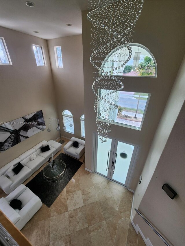 foyer featuring french doors, a high ceiling, and a notable chandelier