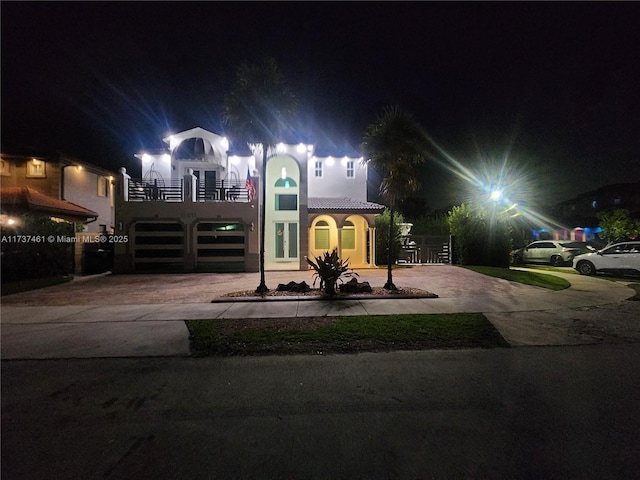 view of front of house featuring a garage, decorative driveway, and a balcony