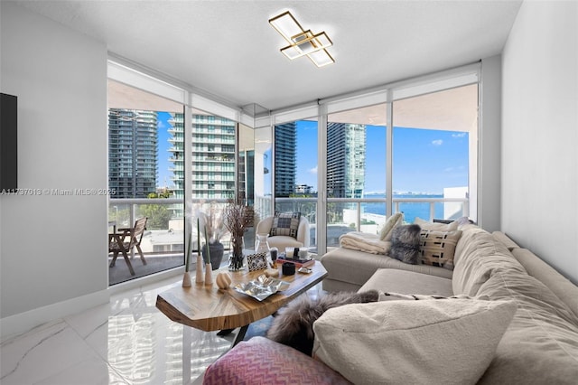 living room with plenty of natural light, floor to ceiling windows, and a water view